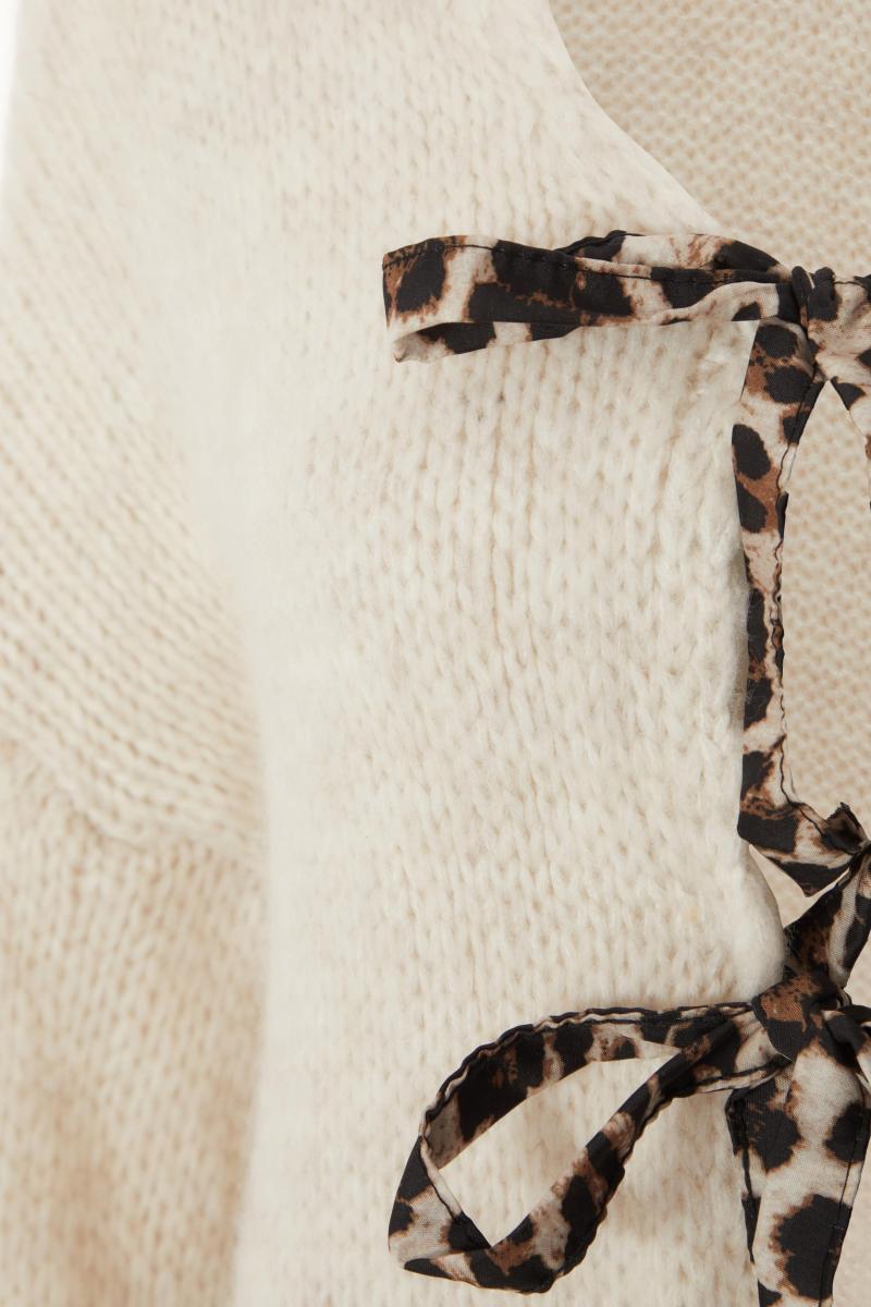 Біля білого трикотажного краватки передній кардиган